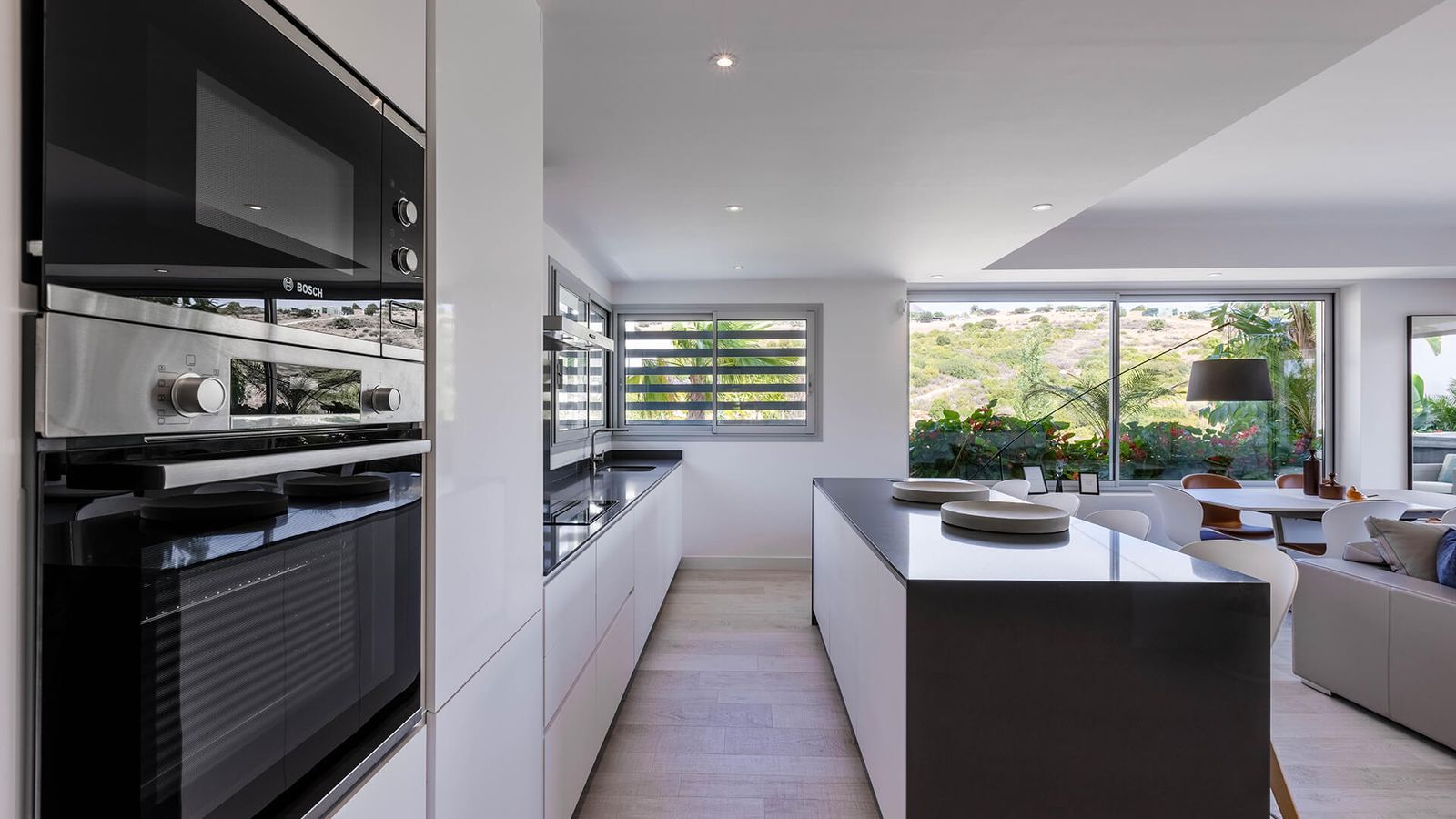 Cocina moderna con electrodomésticos integrados y vistas al jardín en Alcazaba Lagoon.