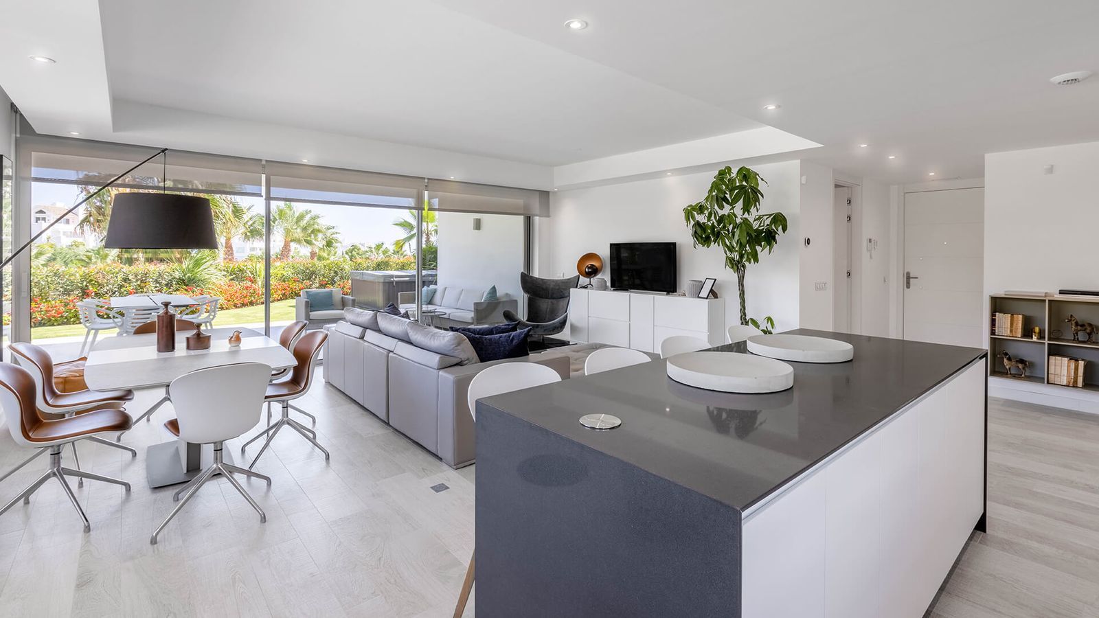 Moderno apartamento de planta abierta con isla de cocina y acceso a la terraza